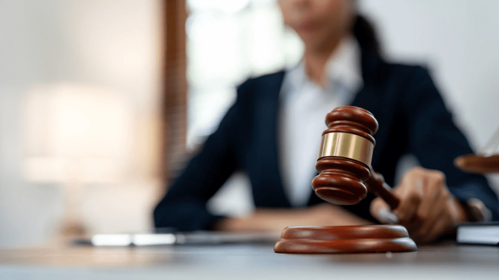 A judge holding a gavel in a courtroom setting.